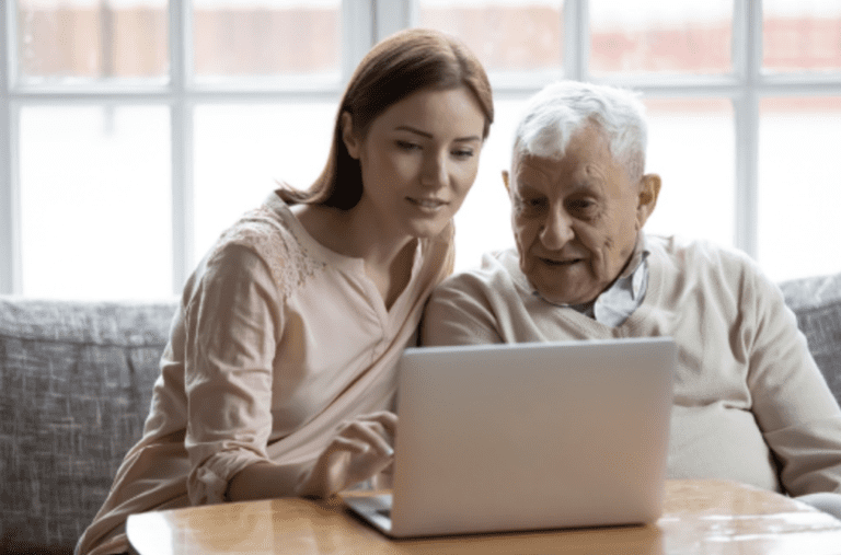 Woman helping elderly on computer